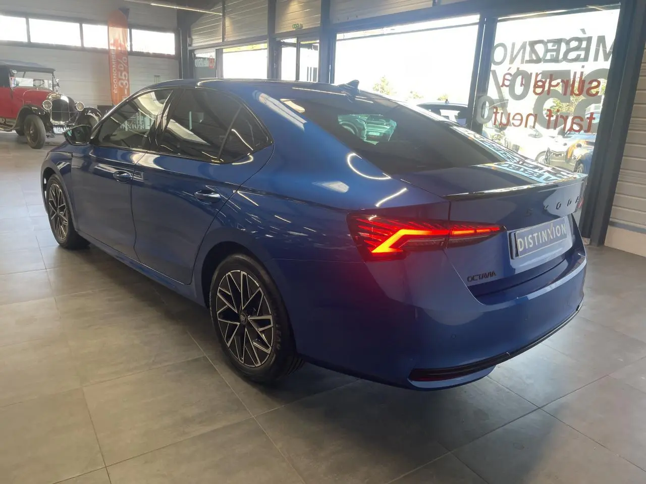 Vue 3/4 arrière droite d'une Skoda Octavia Sportline bleu foncé avec feux arrière LED et jantes alliage noires.