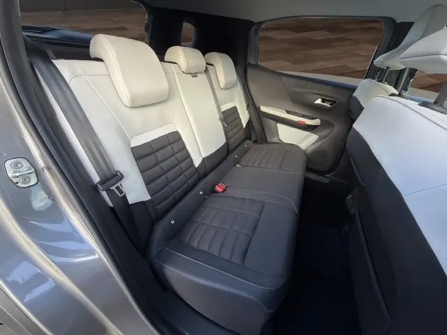 Vue intérieure arrière côté gauche du Citroën C3 Aircross gris foncé, montrant la banquette bi-ton noire et beige.
