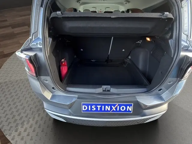 Coffre ouvert vu de l'arrière d'une Citroën C3 Aircross gris foncé, avec banquette arrière et tapis noir visible.