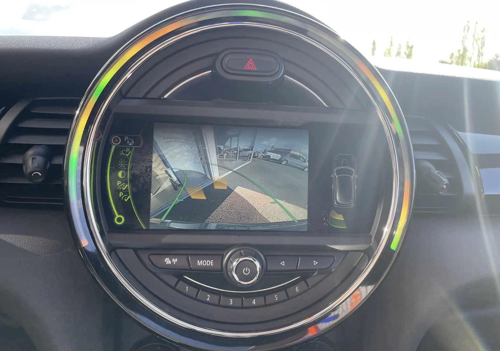 Écran central rond de la MINI F56 Cooper S 2015 montrant la caméra de recul avec guidage et alertes de proximité.