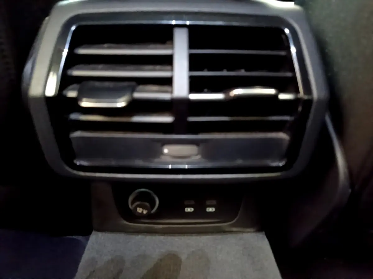 Vue rapprochée de la sortie d'air arrière noire avec prise 12V et ports USB dans un Audi Q3 35 TDI 2021.