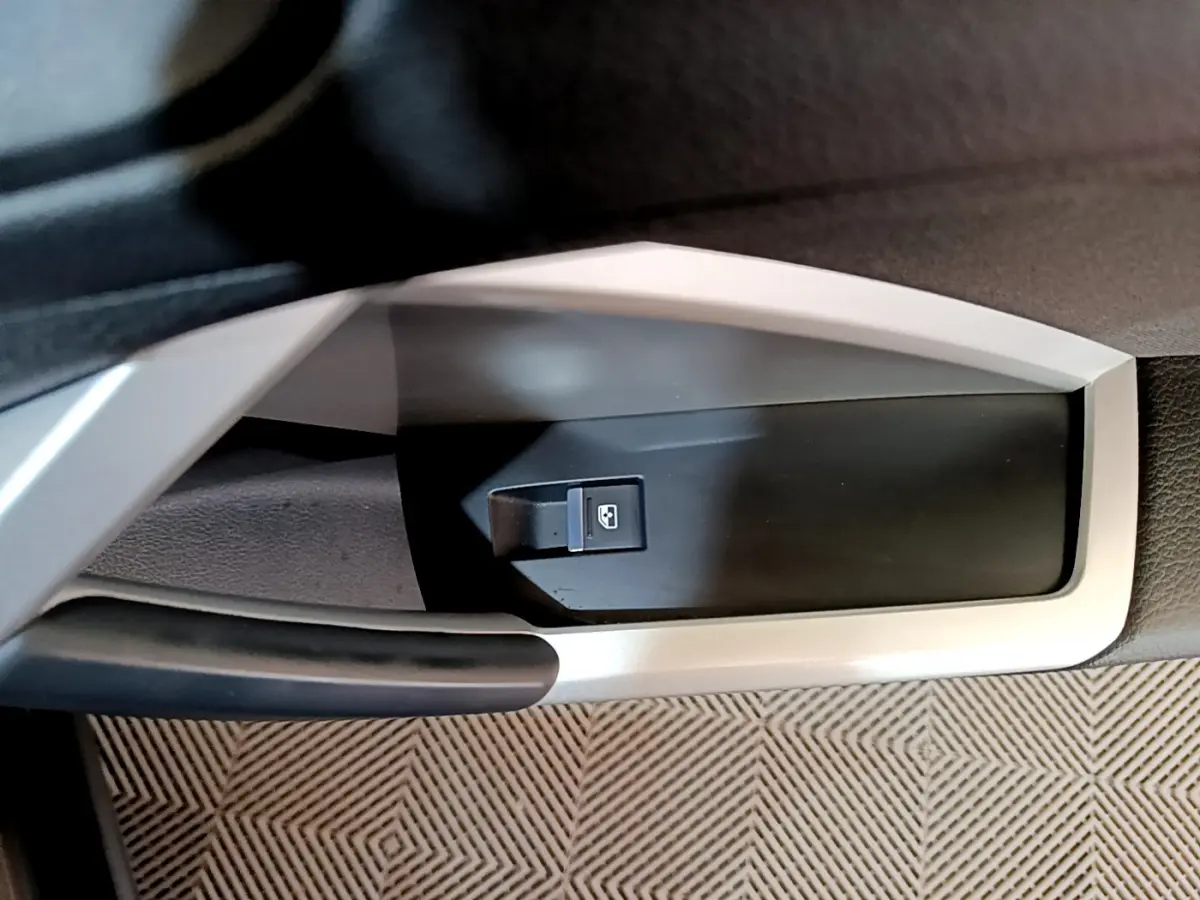 Gros plan sur la commande de lève-vitre côté conducteur de l'Audi Q3 35 TDI Business Line noire, intérieur moderne.