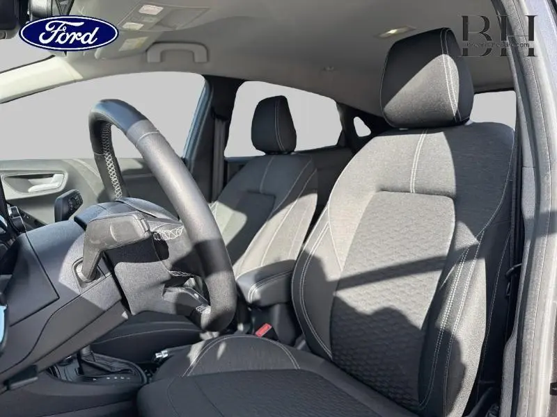 Vue intérieure côté conducteur du Ford Puma 2020, sièges sport tissu noir Alhambra avec surpiqûres blanches.