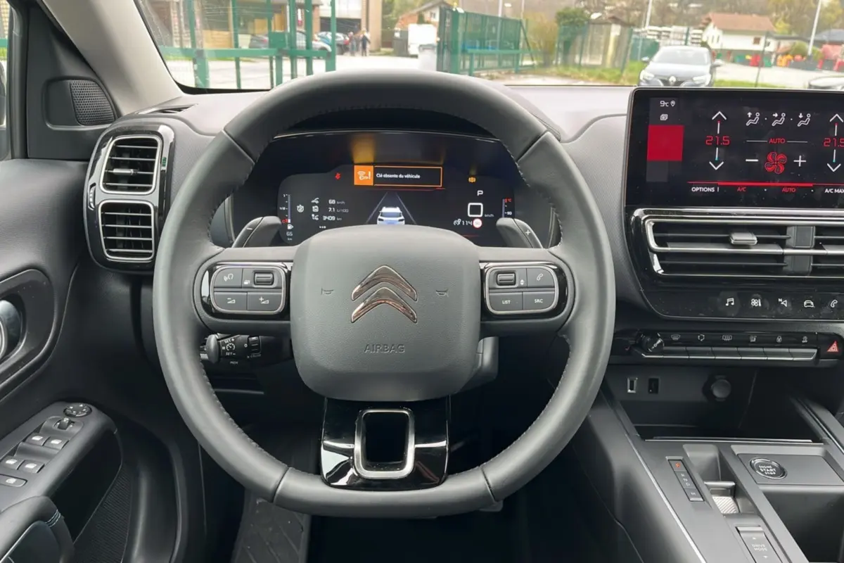 Vue frontale intérieure du volant cuir multifonctions et tableau de bord numérique du Citroën C5 Aircross Hybrid 2025.