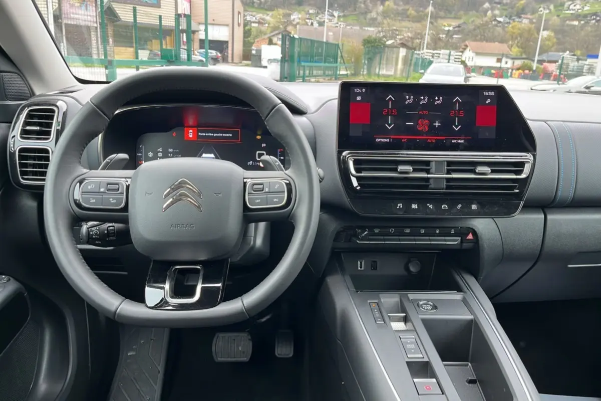 Vue intérieure centrée sur le volant cuir multifonctions et l’écran tactile du tableau de bord du Citroën C5 Aircross.