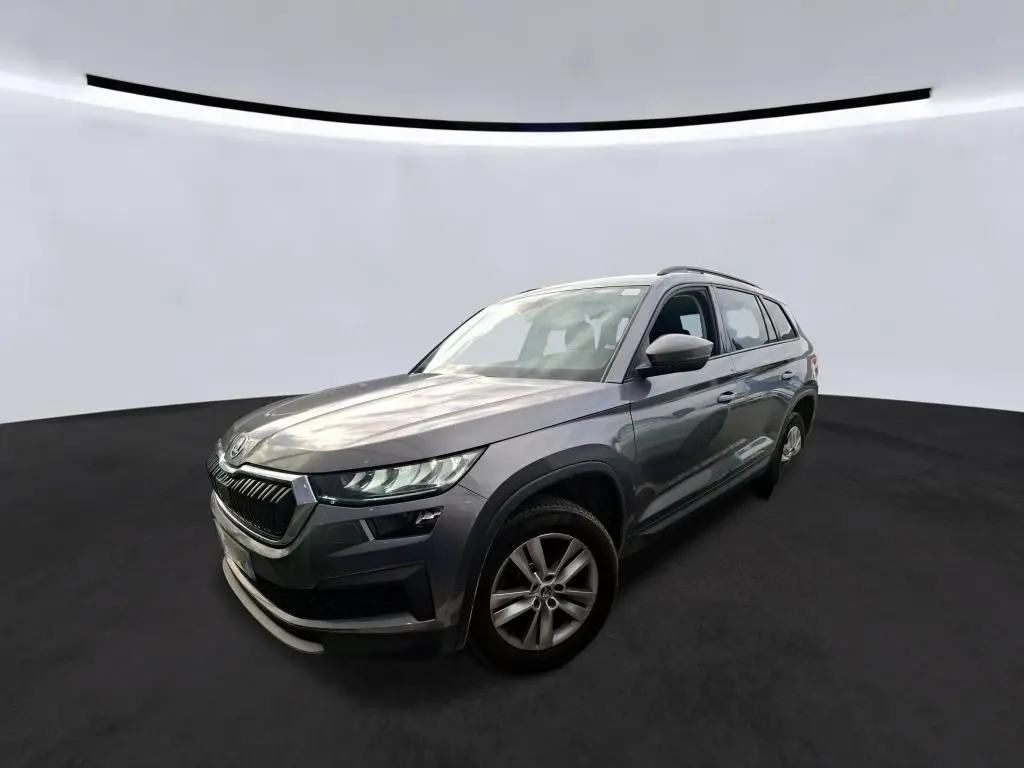 Vue 3/4 avant droit d'un Skoda Kodiaq gris 2023 avec jantes alu 17 pouces et calandre noire chromée.