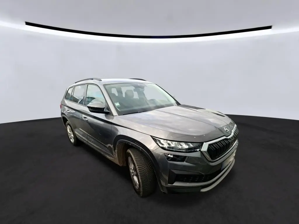 Vue 3/4 avant droit d'un Skoda Kodiaq gris 2023 avec calandre noire et jantes alu 17 pouces.