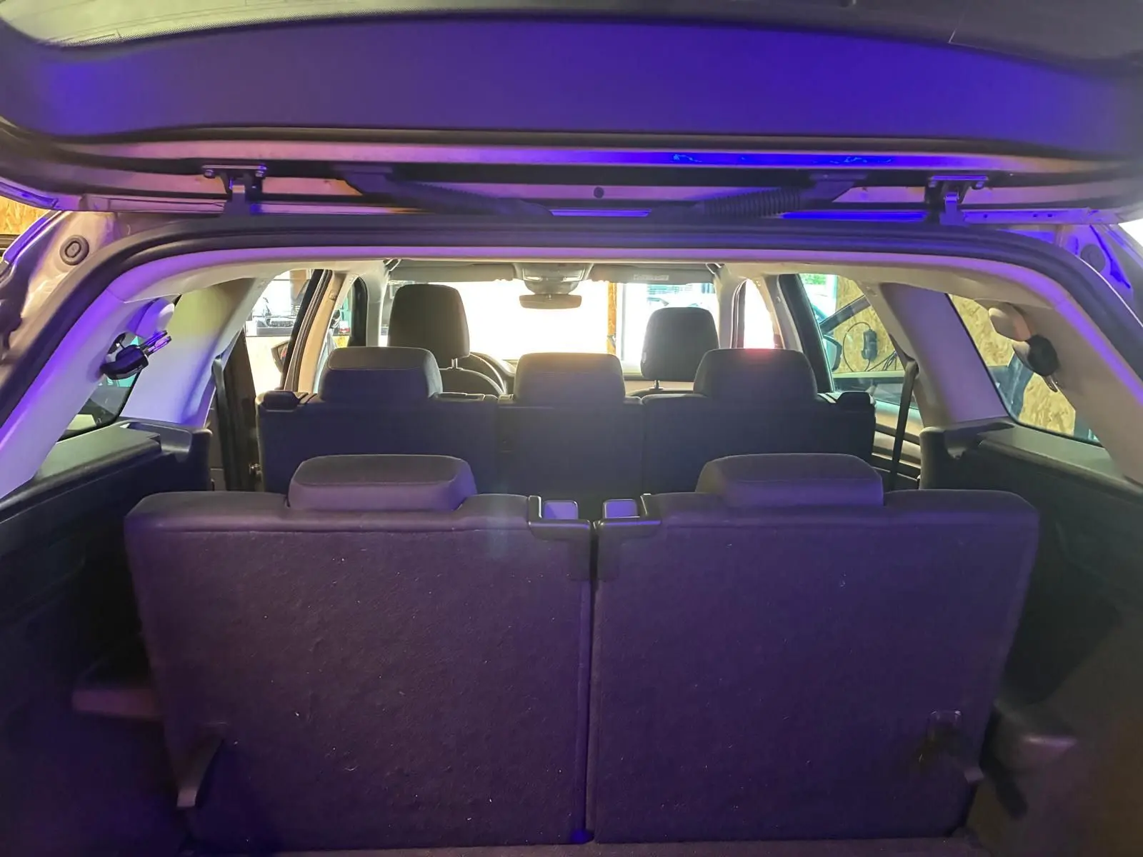 Vue arrière intérieure du Skoda Kodiaq gris 7 places, montrant la troisième rangée de sièges relevée.