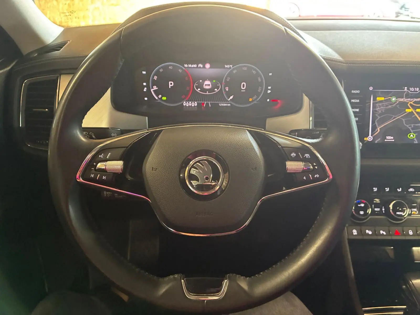 Vue rapprochée du volant noir et du tableau de bord digital du Skoda Kodiaq 2023 avec écran GPS allumé.