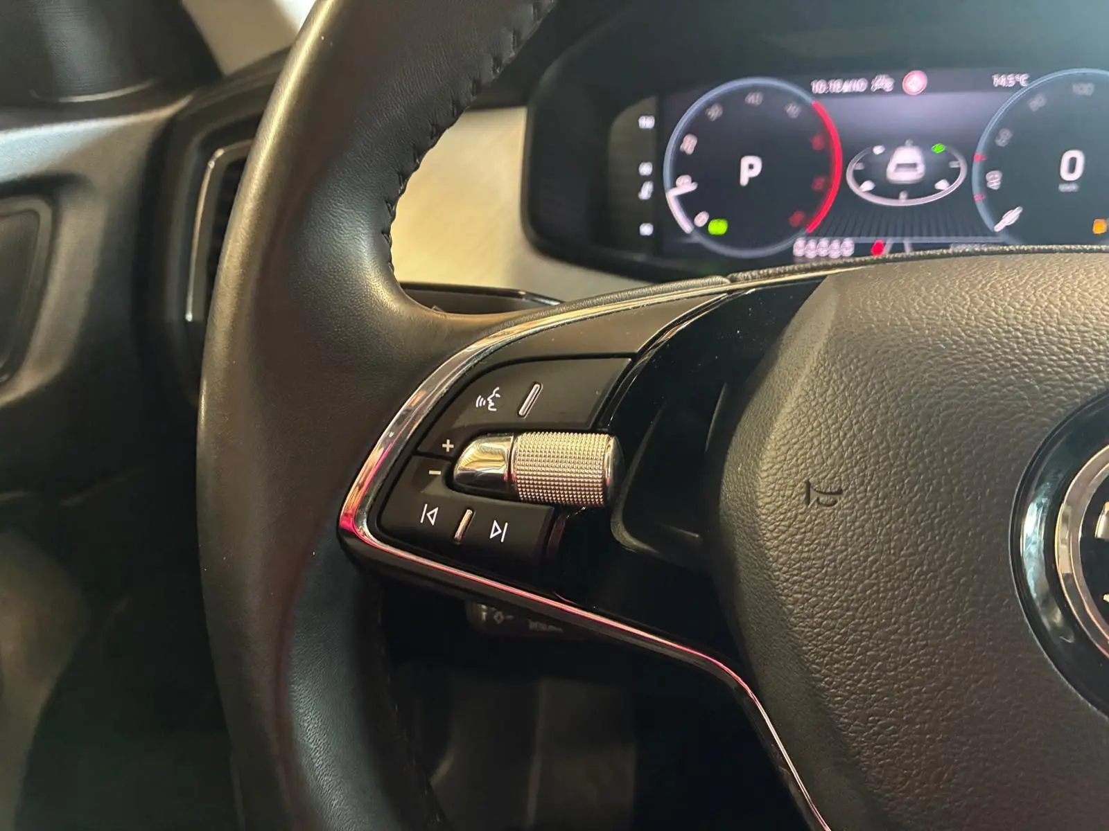 Gros plan sur le volant cuir noir du Skoda Kodiaq 2023 avec commandes intégrées et tableau de bord numérique.