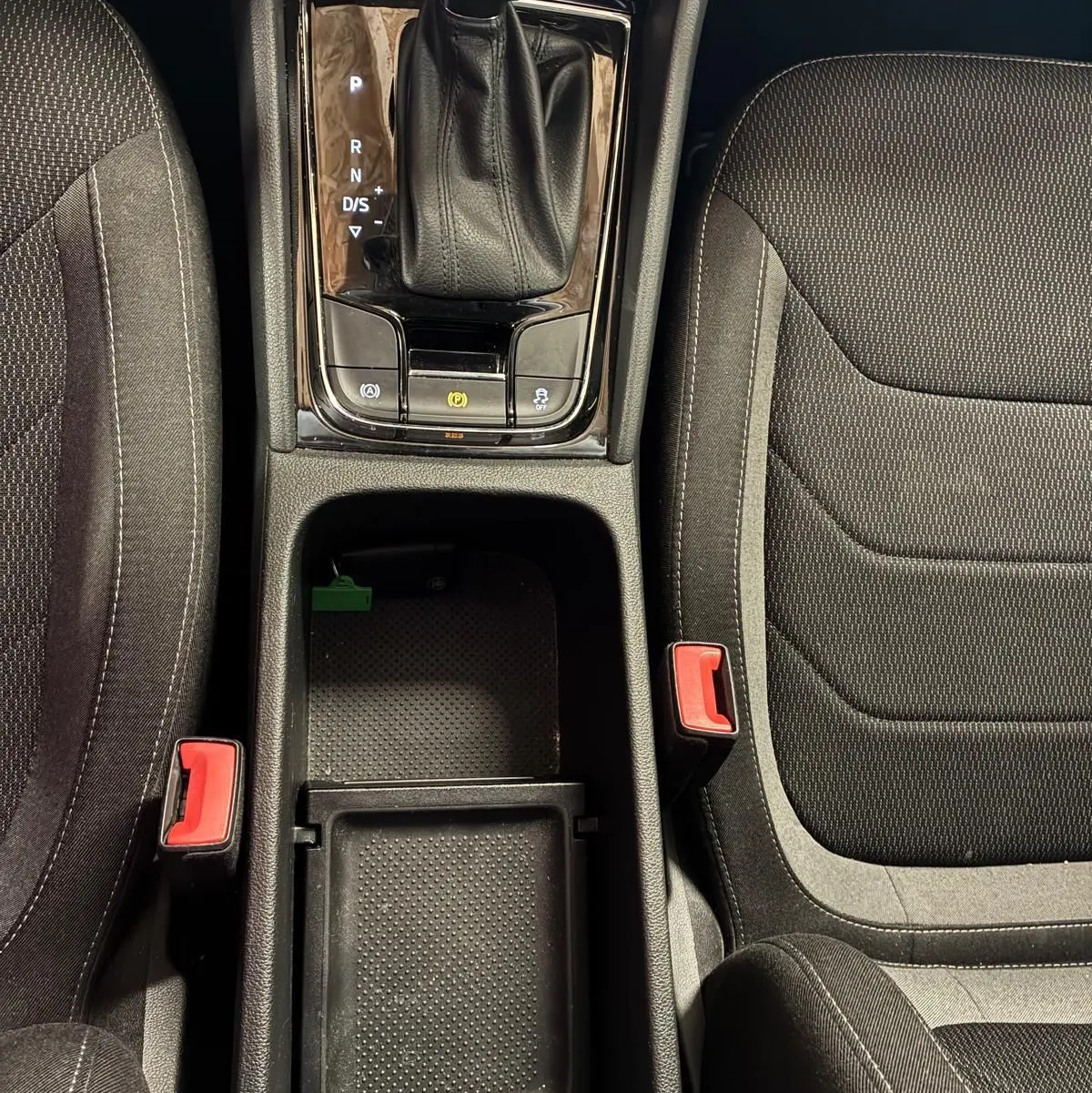 Vue plongeante sur la console centrale noire avec levier de vitesses Skoda et sièges tissu gris du Skoda Kodiaq 2023.