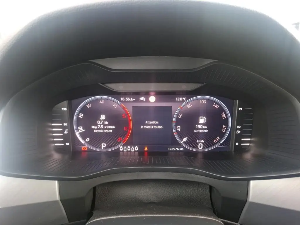 Tableau de bord numérique du Skoda Kodiaq gris, affichage de la vitesse, autonomie et alertes moteur.