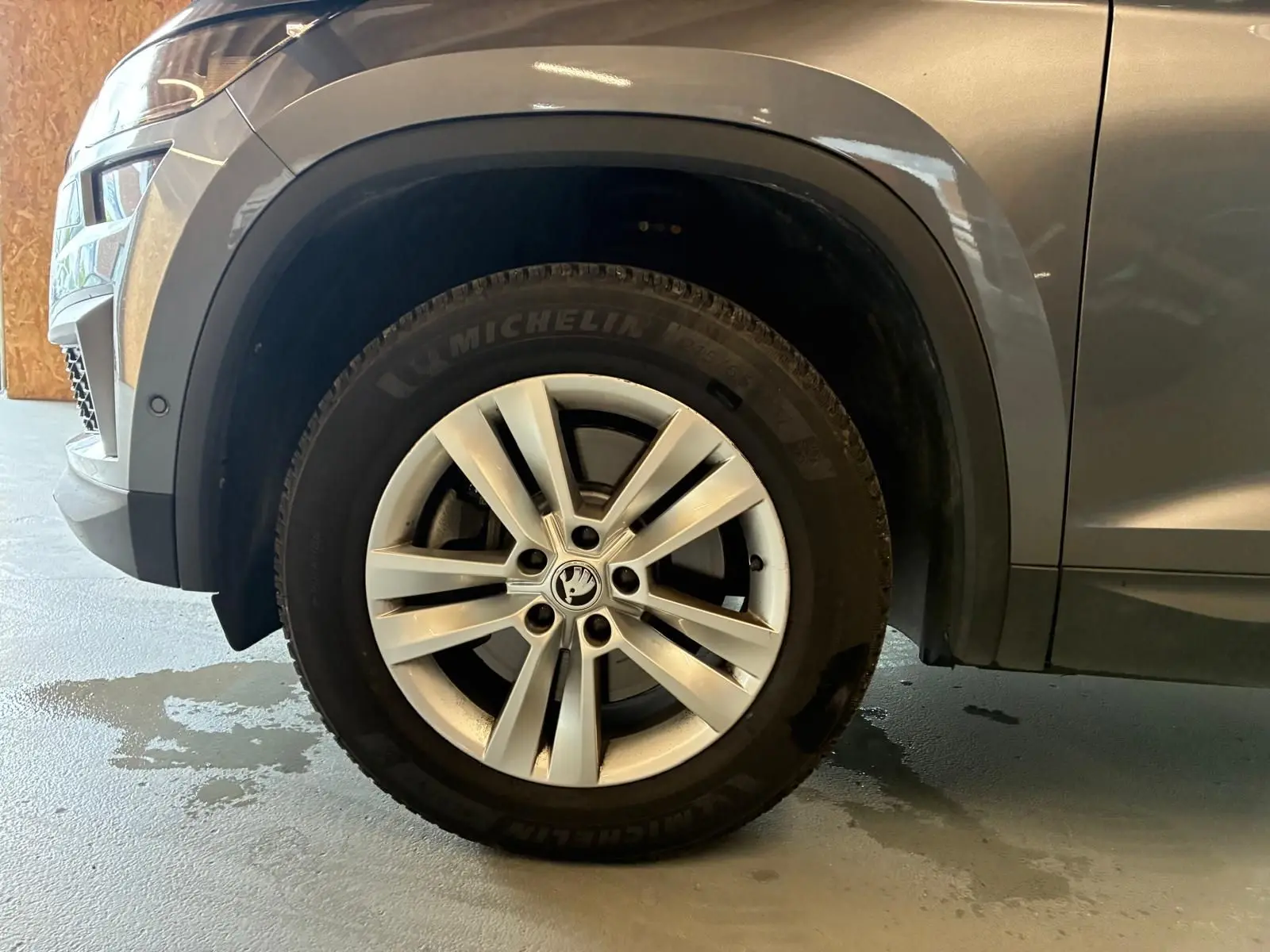 Gros plan sur la roue avant gauche du Skoda Kodiaq gris, avec jante alu 17 pouces et passage de roue noir mat.