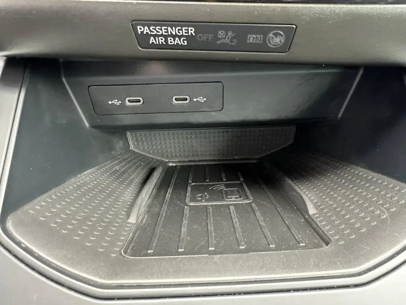 Vue rapprochée de la zone de recharge sans fil et ports USB-C du SEAT Arona 2025, intérieur noir.