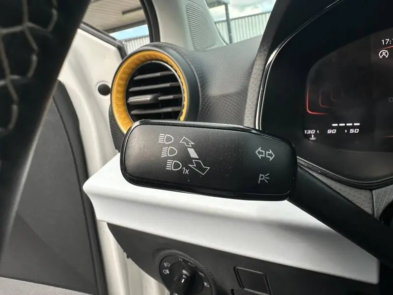 Gros plan sur la commande des feux et clignotants à gauche du volant dans l’habitacle blanc et gris du SEAT Arona 2025.
