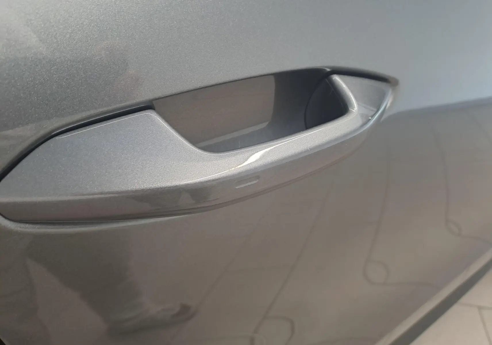 Poignée de porte gris graphite en gros plan sur un Skoda Kodiaq 2.0 TDI 150 DSG7 Selection 7 places, vue latérale.