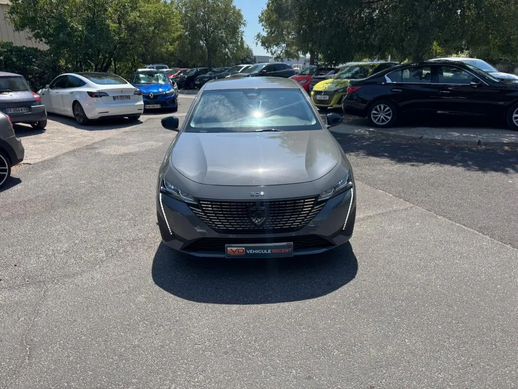 Peugeot 308 gris vue de face, mettant en valeur sa calandre distinctive et ses phares LED fins.