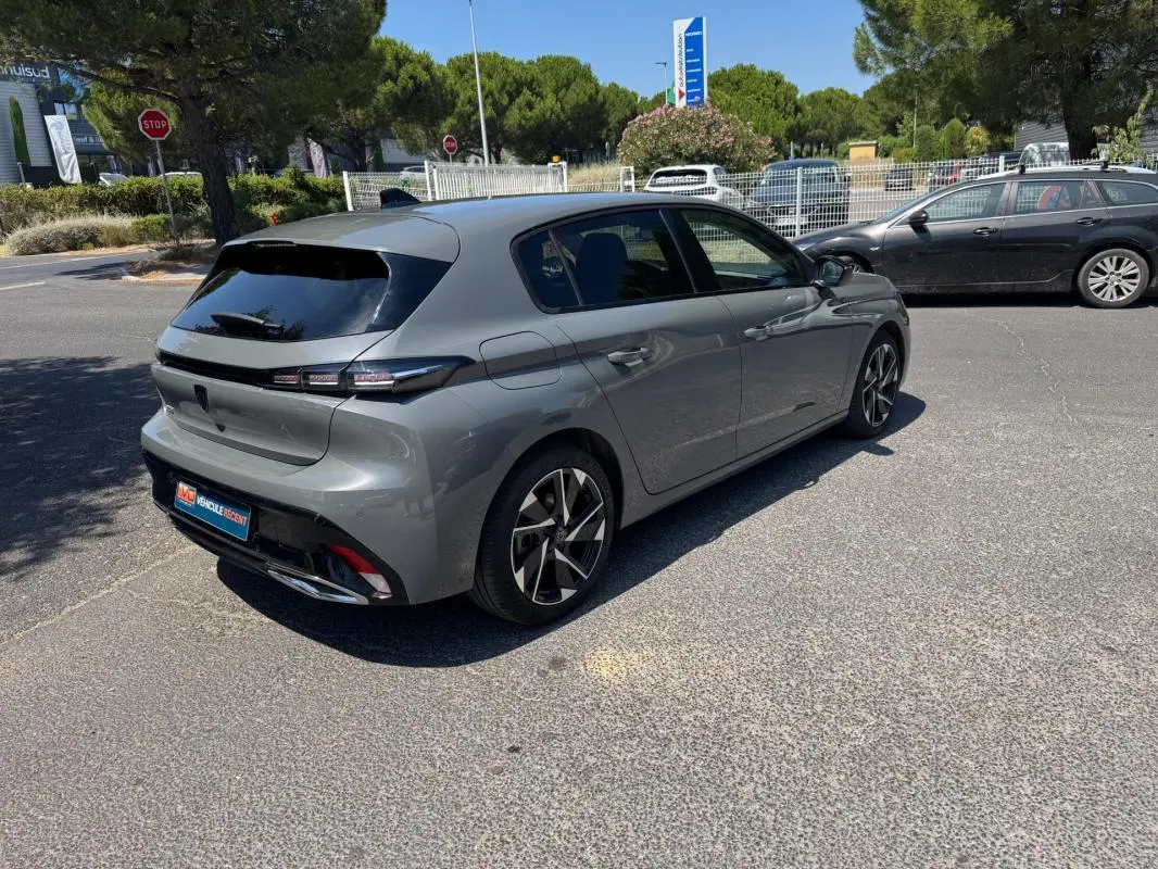 PEUGEOT 308 gris vue 3/4 arrière droit, jantes alliage 17 pouces et vitres teintées en extérieur.