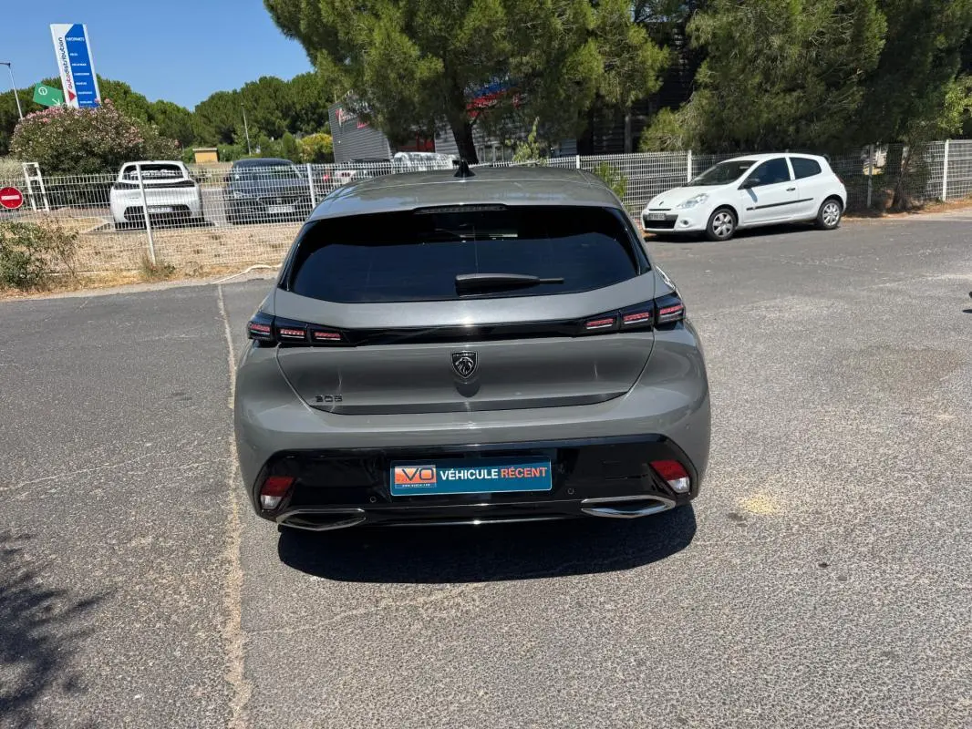 Vue arrière d'une Peugeot 308 gris métallisé 2025 avec feux LED et double sortie d'échappement intégrée.