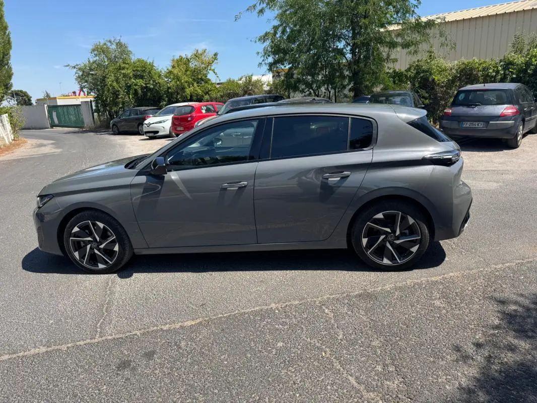 Peugeot 308 BlueHDi gris vue de profil côté gauche, avec jantes alliage 17 pouces et vitres teintées.