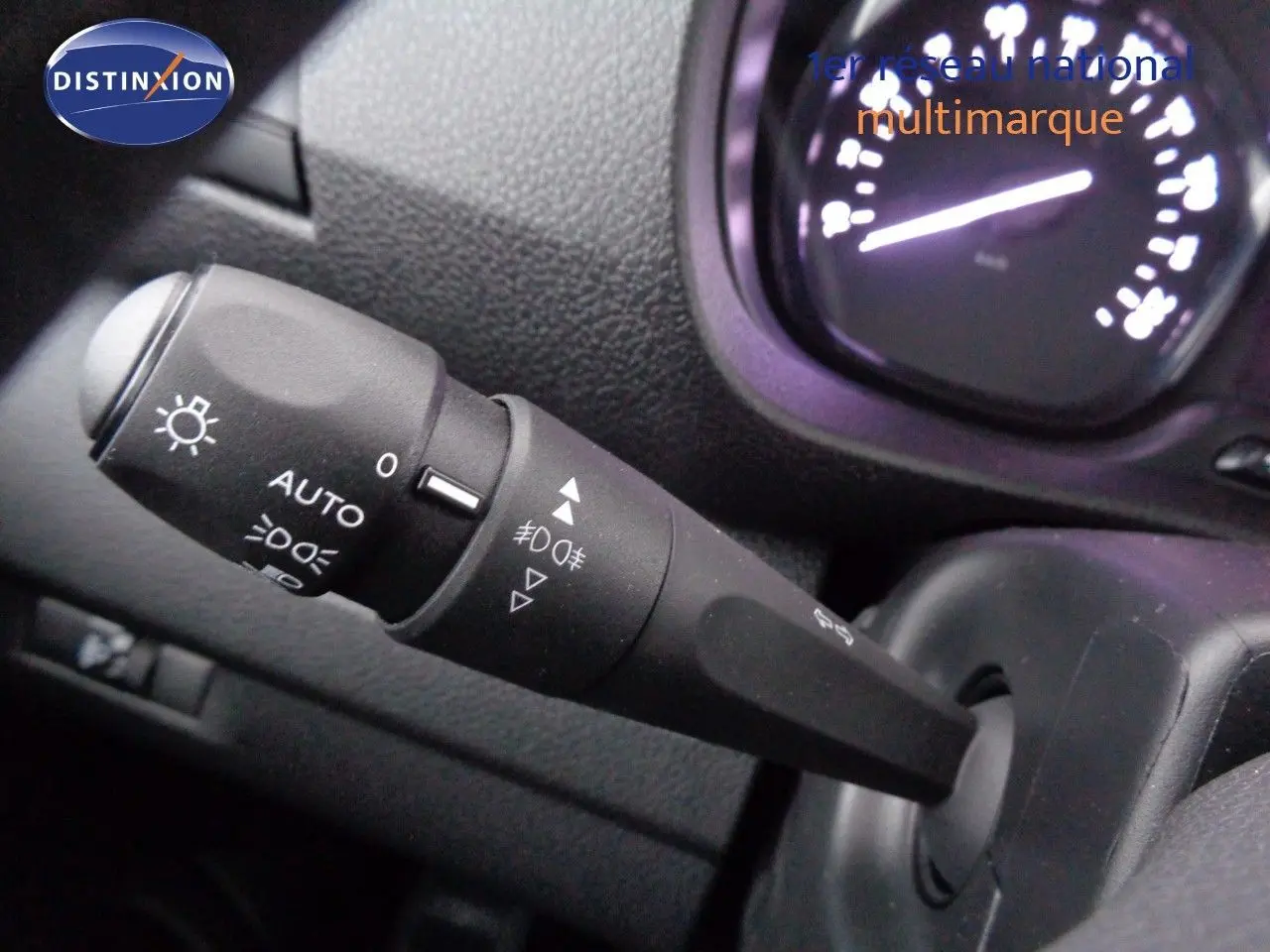 Gros plan sur la commande des phares du Peugeot Expert Fourgon noir métal, avec tableau de bord partiellement visible.