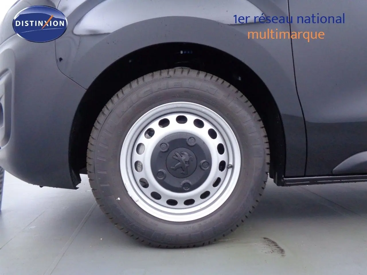 Vue intérieure côté conducteur du Peugeot Expert Fourgon 2022, tableau de bord et sièges noirs en tissu gris.