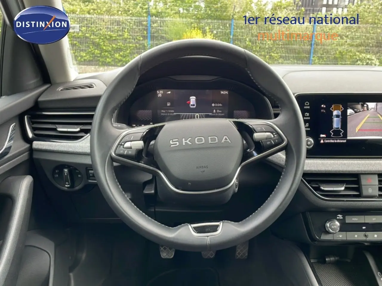 Vue centrée sur le volant cuir noir de la Skoda Scala blanc glacier avec tableau de bord digital et écran multimédia.