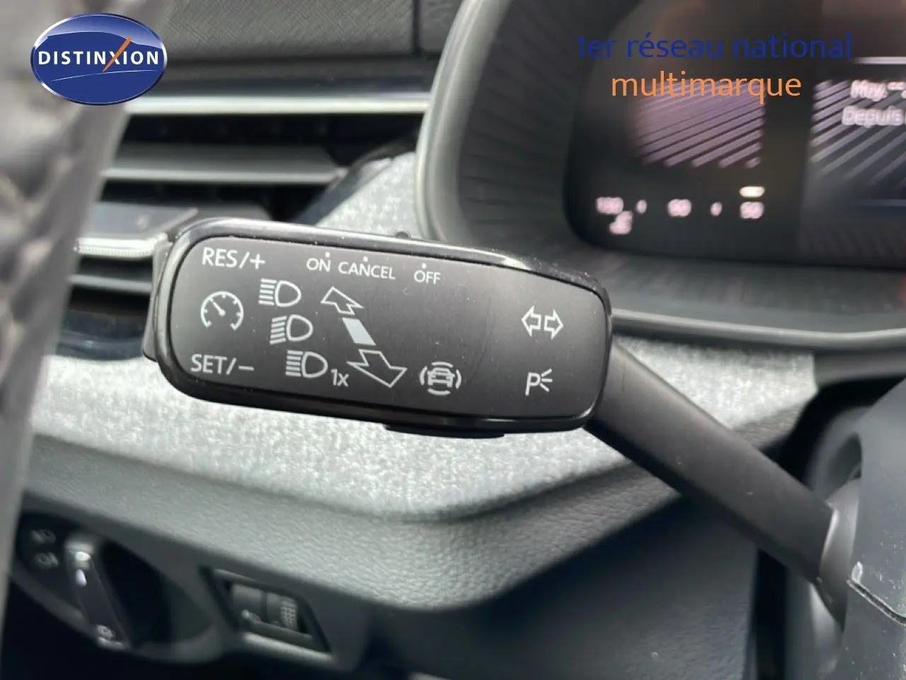 Gros plan sur la commande de régulateur de vitesse au volant d’une Skoda Scala blanc glacier 2025, intérieur gris noir.