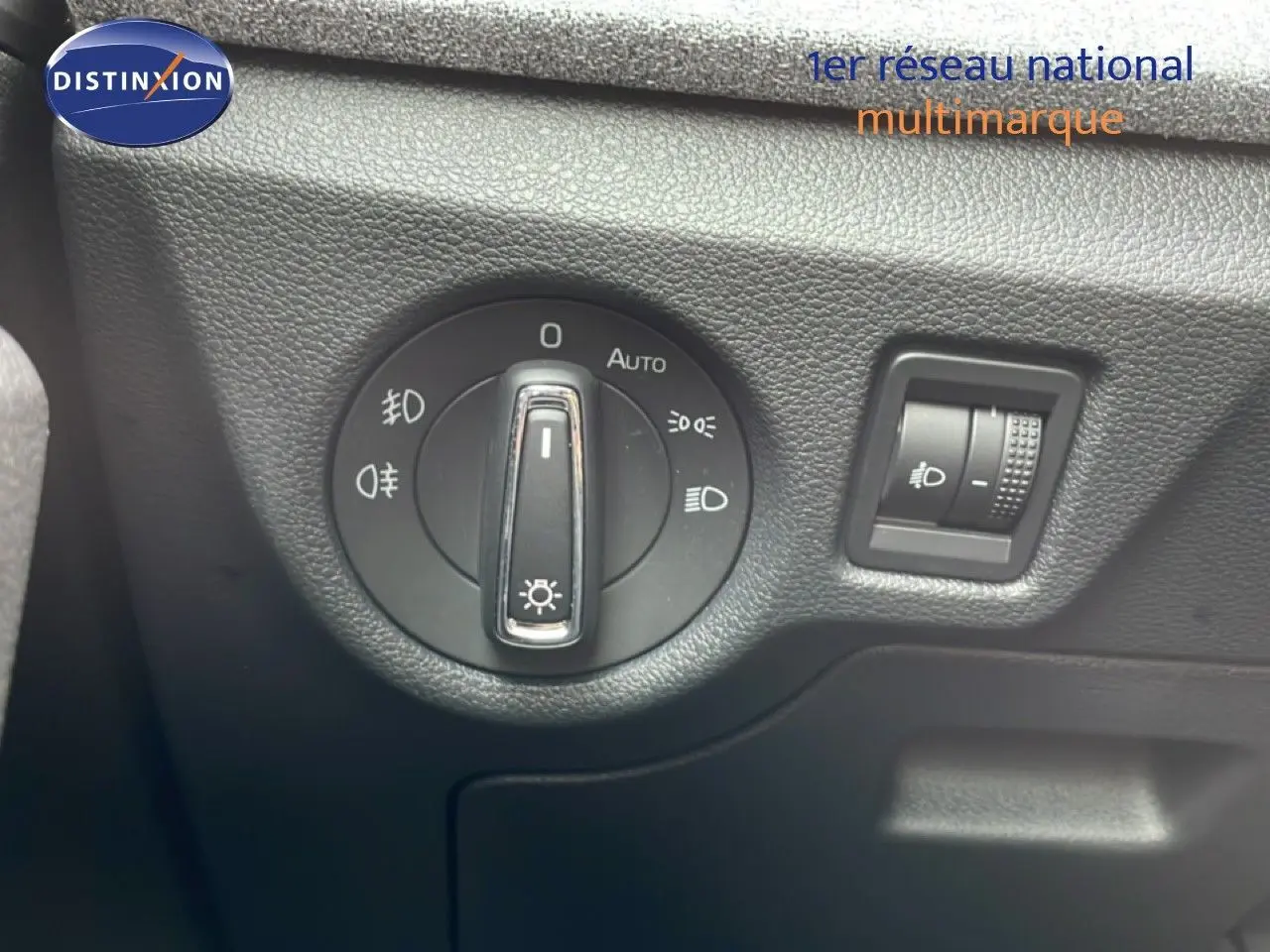 Gros plan sur le sélecteur d'éclairage noir du tableau de bord d'une Skoda Scala blanc glacier, version 2025.