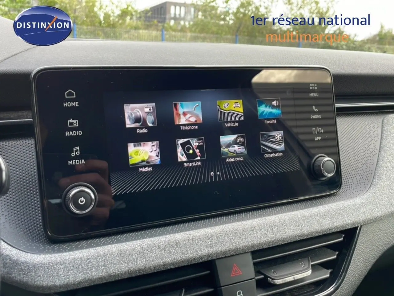 Écran tactile central de la Skoda Scala blanc glacier, vue rapprochée du tableau de bord avec interface multimédia active.