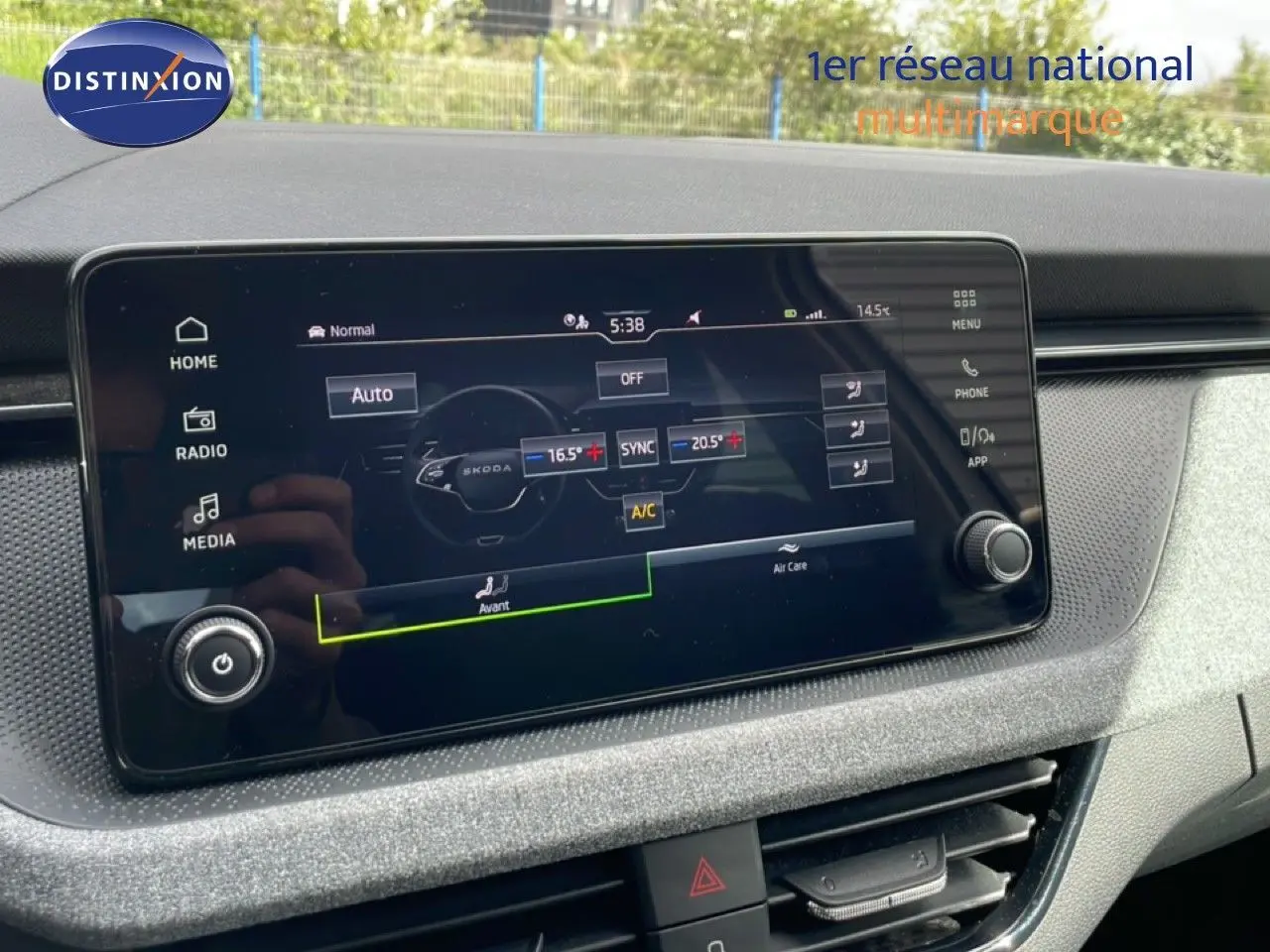 Écran tactile central affichant la climatisation dans l’habitacle gris clair d’une Skoda Scala blanche.