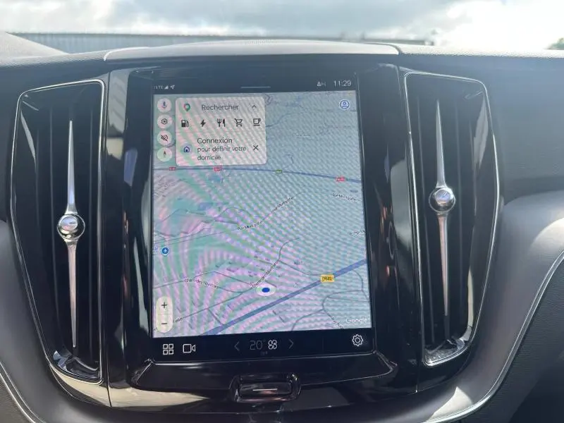 Écran tactile central du tableau de bord du Volvo XC60 2024, avec affichage GPS et aérateurs verticaux noirs.