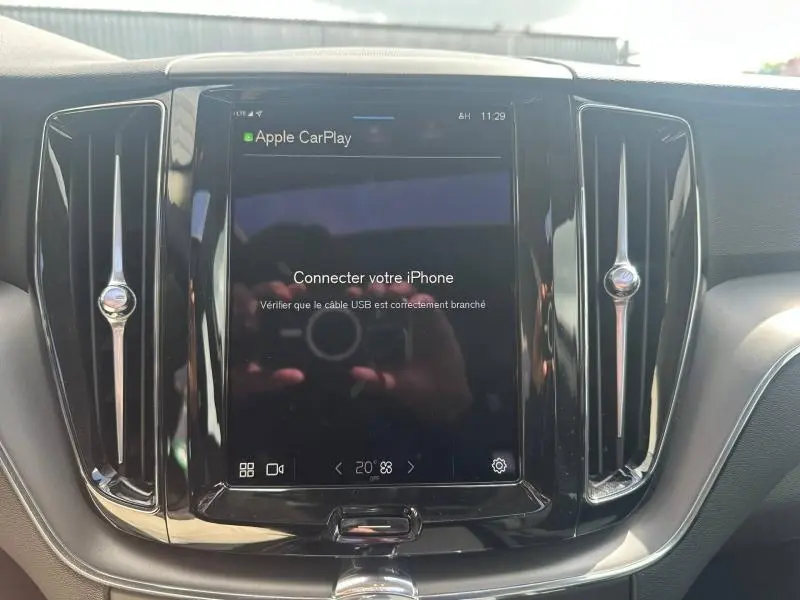 Écran tactile central du tableau de bord du Volvo XC60 gris 2024 avec interface Apple CarPlay affichée.