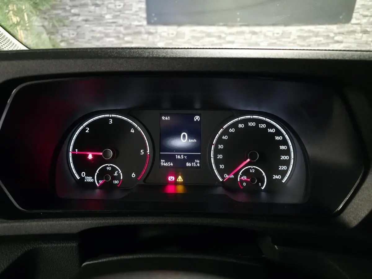 Vue rapprochée du combiné d'instruments du Volkswagen Caddy blanc, affichant vitesse, régime et alertes au tableau de bord.
