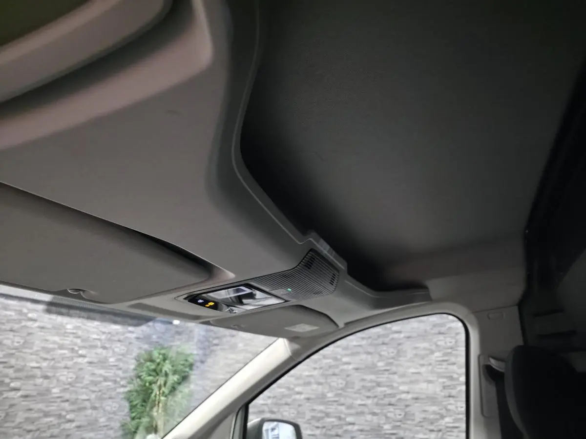 Vue intérieure du plafond et pare-soleil côté conducteur du Volkswagen Caddy Cargo blanc avec commandes d’éclairage intégrées.