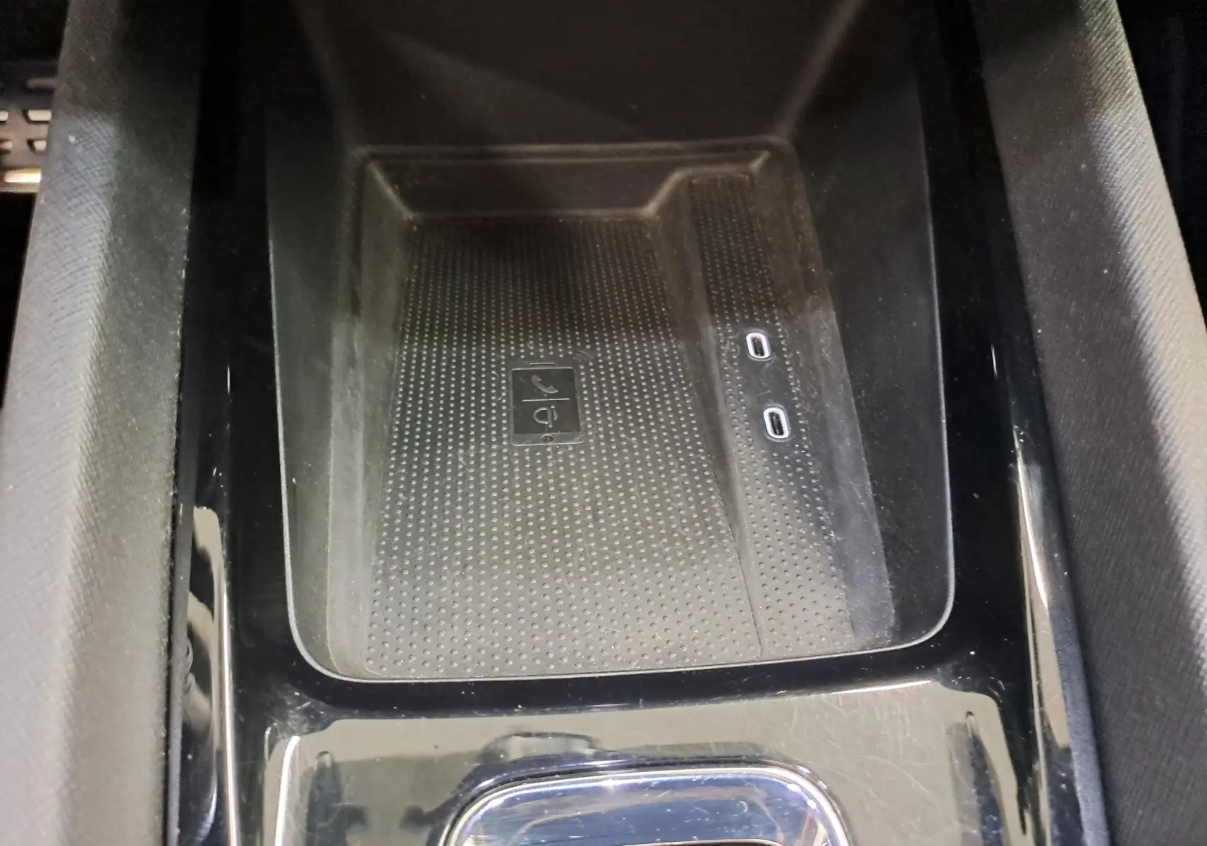 Gros plan sur la console centrale noire avec zone de recharge sans fil et deux ports USB-C dans une Skoda Octavia Combi gris perle.