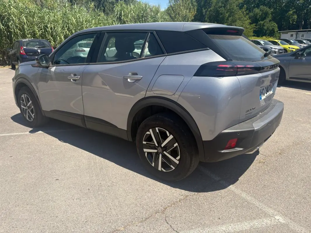 Peugeot 2008 Hybrid gris en 3/4 arrière droit, avec jantes 16 pouces et toit noir contrasté.
