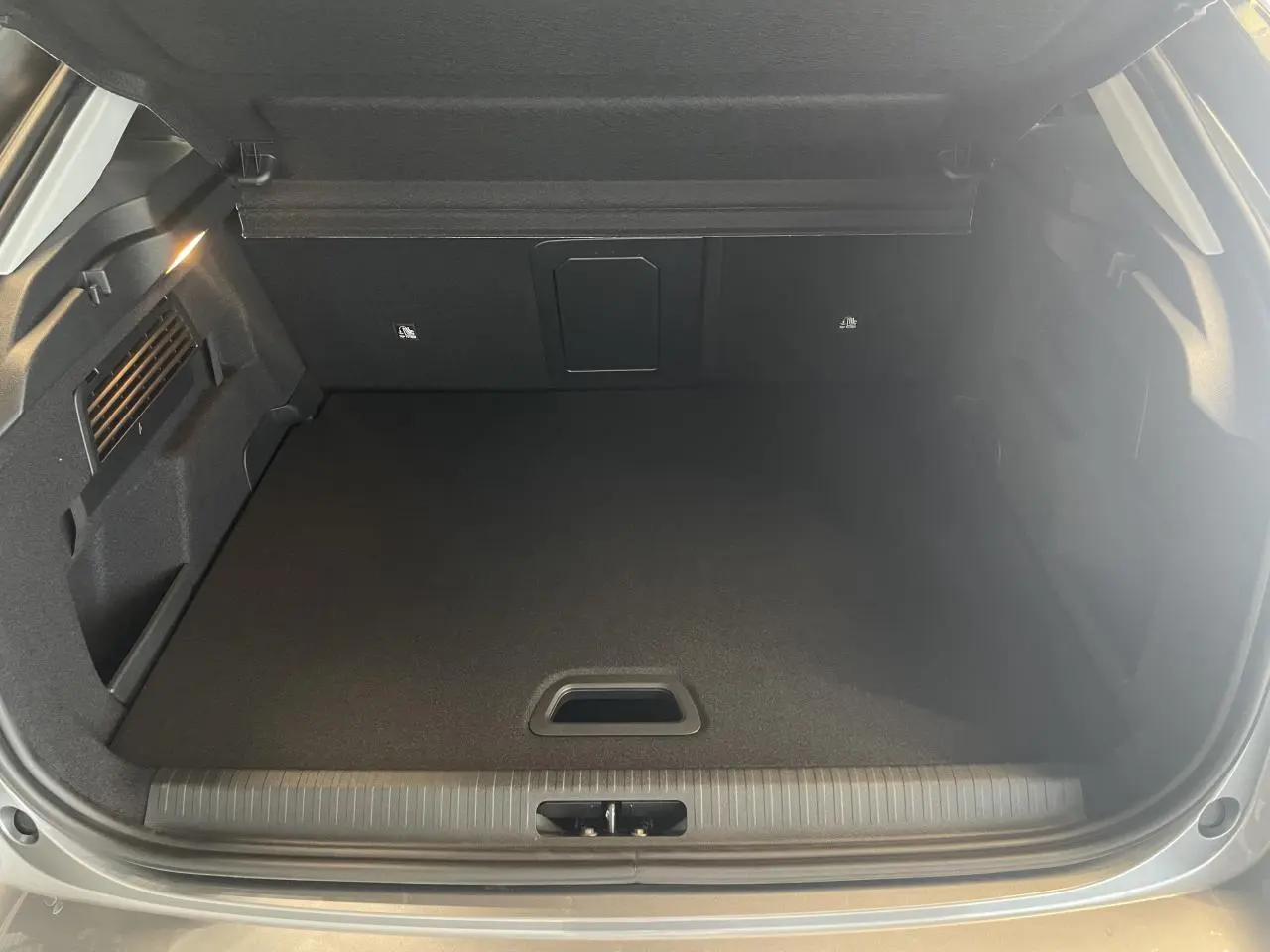 Coffre ouvert de la Citroën C4 gris, vue intérieure montrant un espace de rangement propre et bien fini.