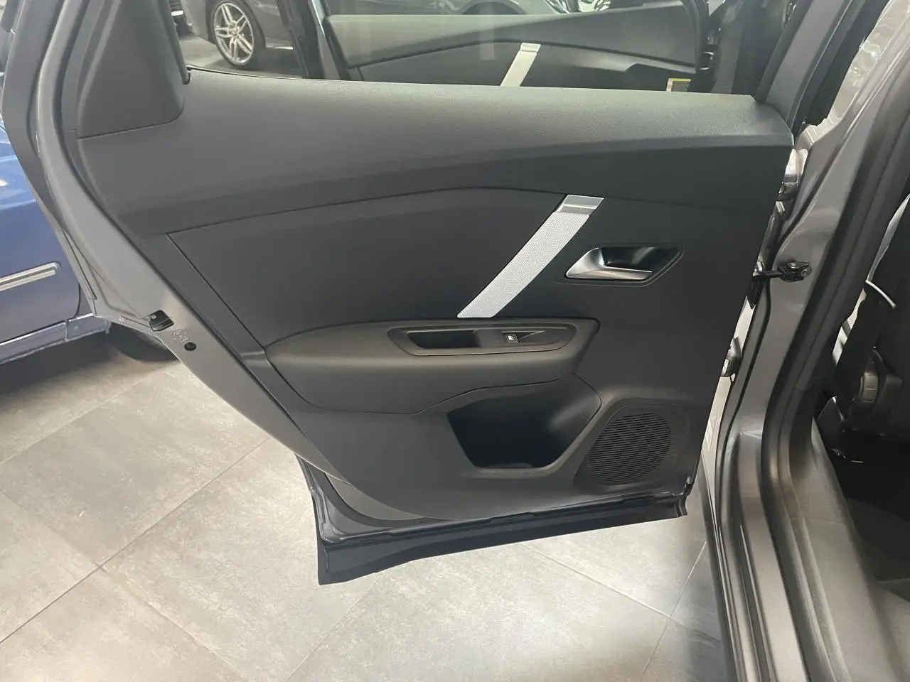 Vue intérieure de la porte arrière droite grise de la Citroën C4 avec garniture noire et insert argenté.