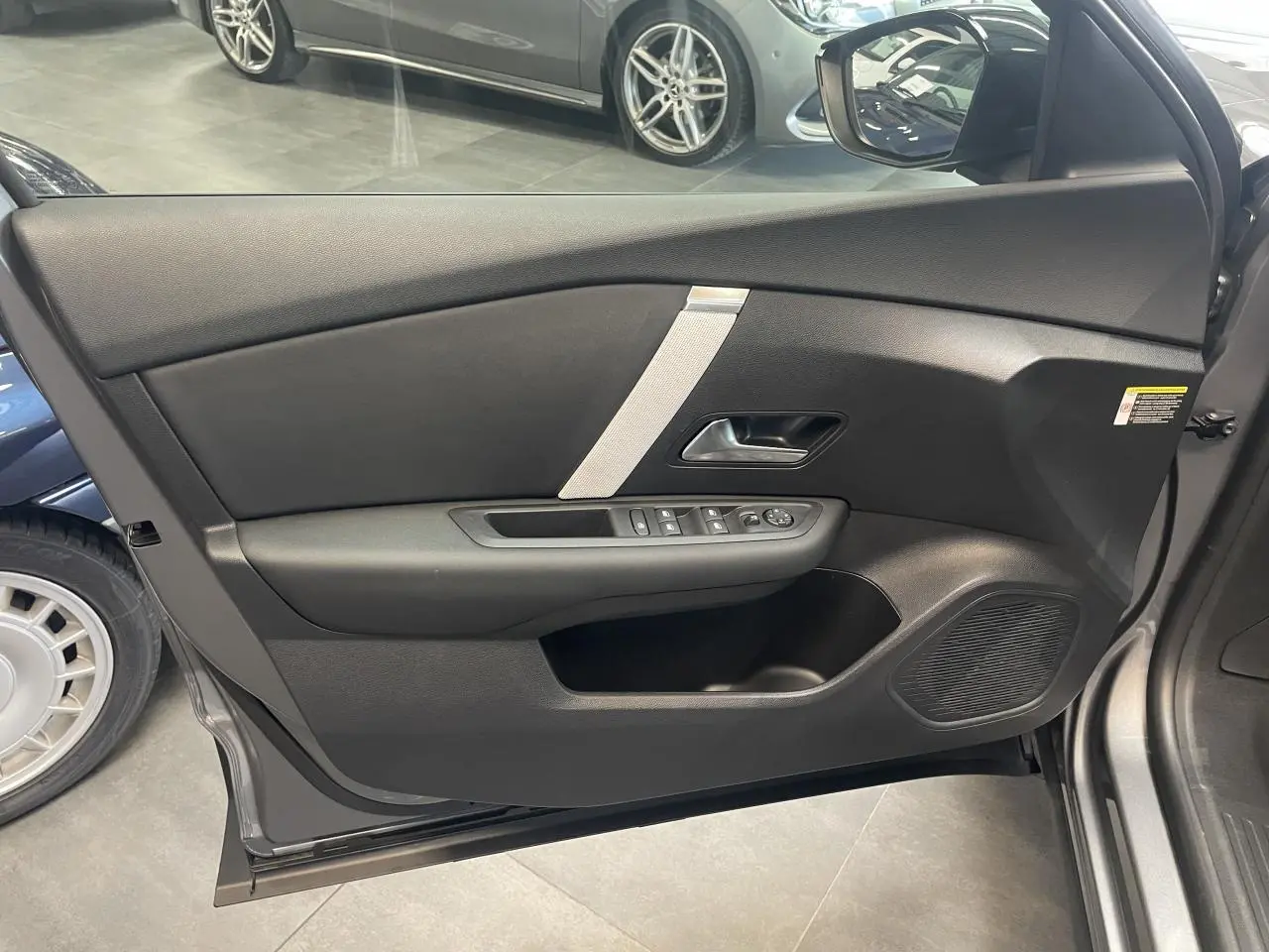 Vue intérieure côté gauche de la porte avant gris métallisé de la Citroën C4 avec commandes de vitres et haut-parleur intégré.