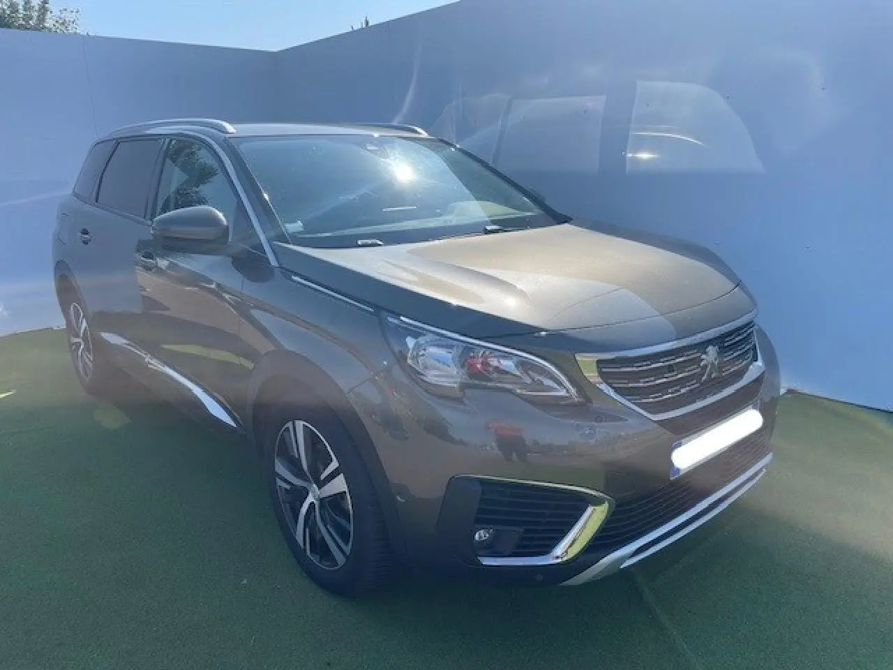 Peugeot 5008 gris amazonite vue 3/4 avant droit, avec calandre chromée et jantes alliage distinctives.