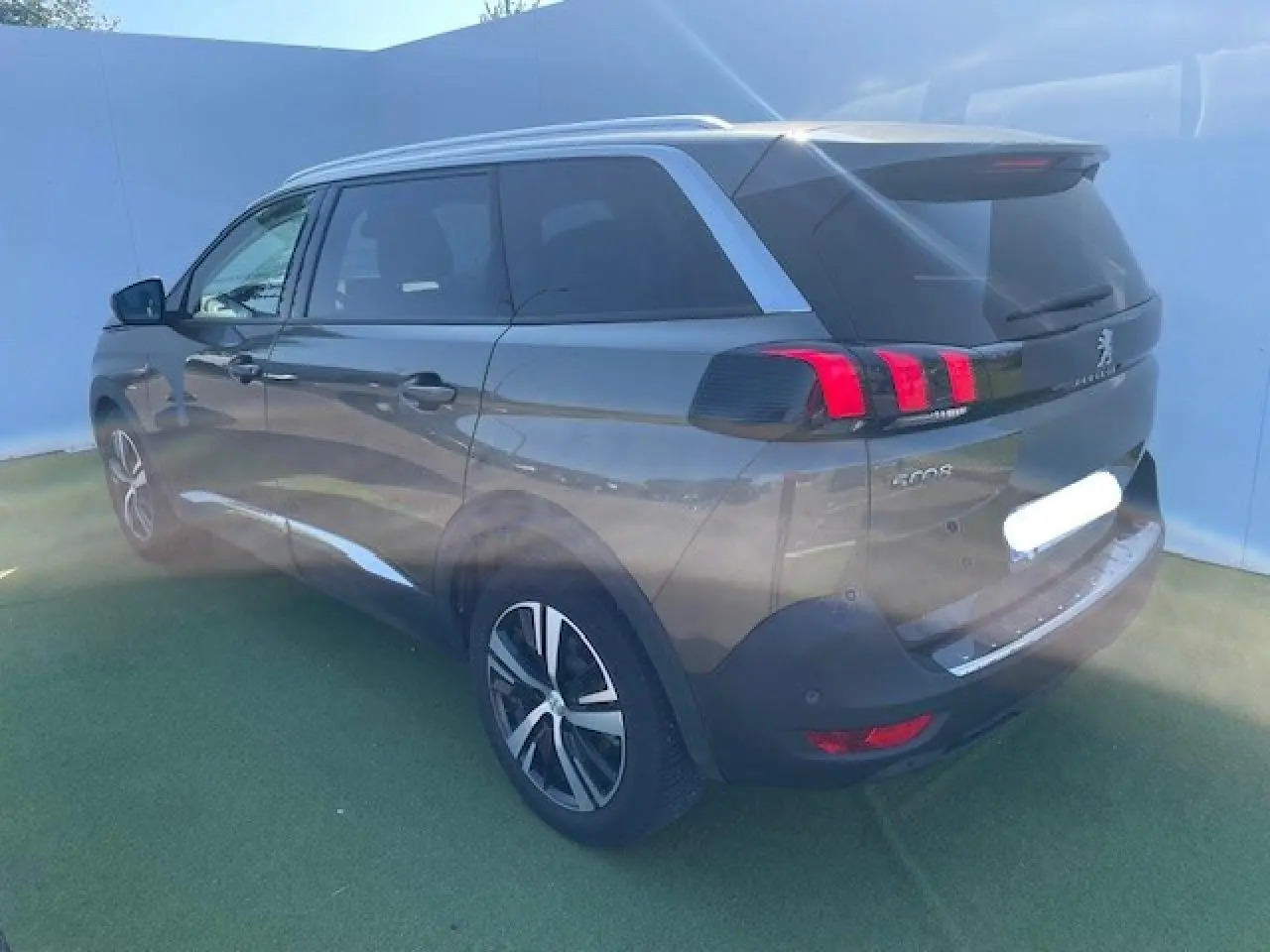 Peugeot 5008 gris amazonite vue 3/4 arrière droit, feux arrière à griffes rouges et jantes alliage visibles
