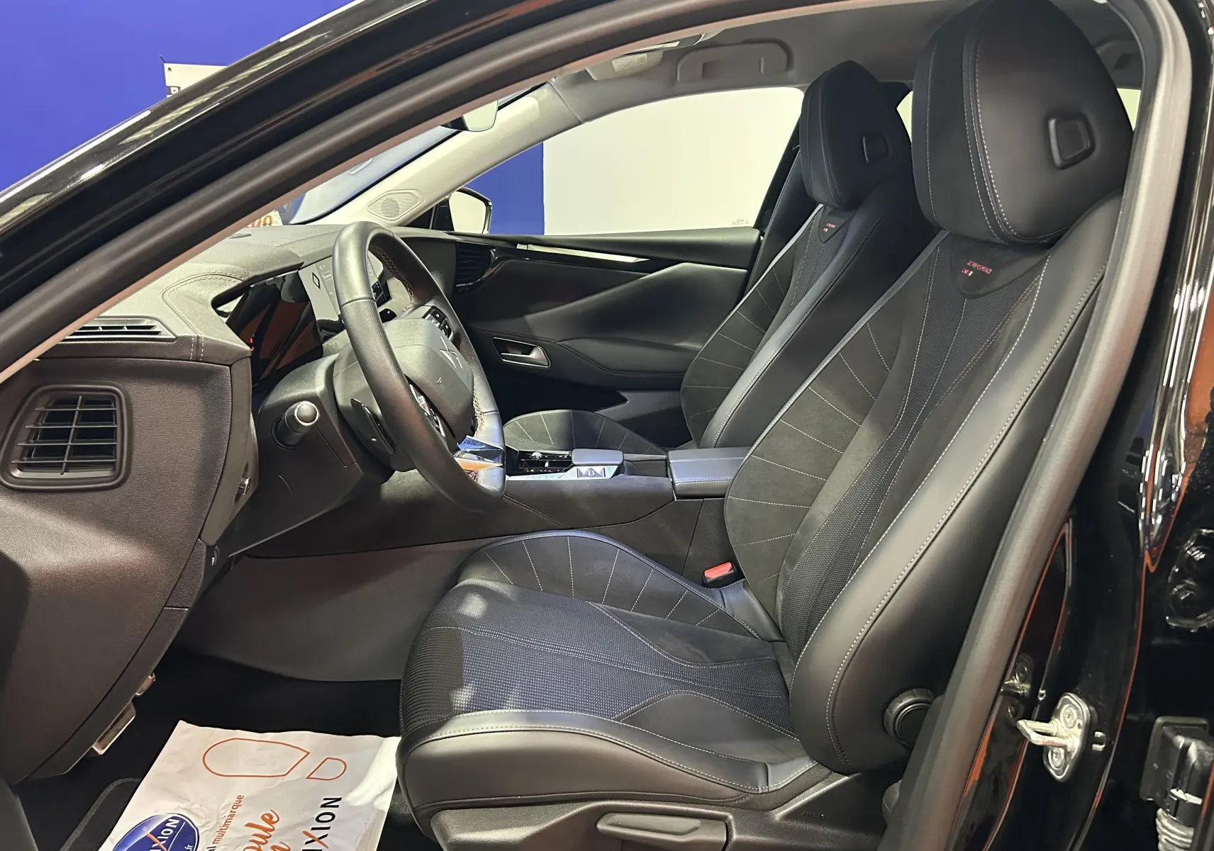 Vue intérieure côté conducteur du DS4 2024 noir Perla Nera, sièges sport en cuir et alcantara avec surpiqûres contrastées.