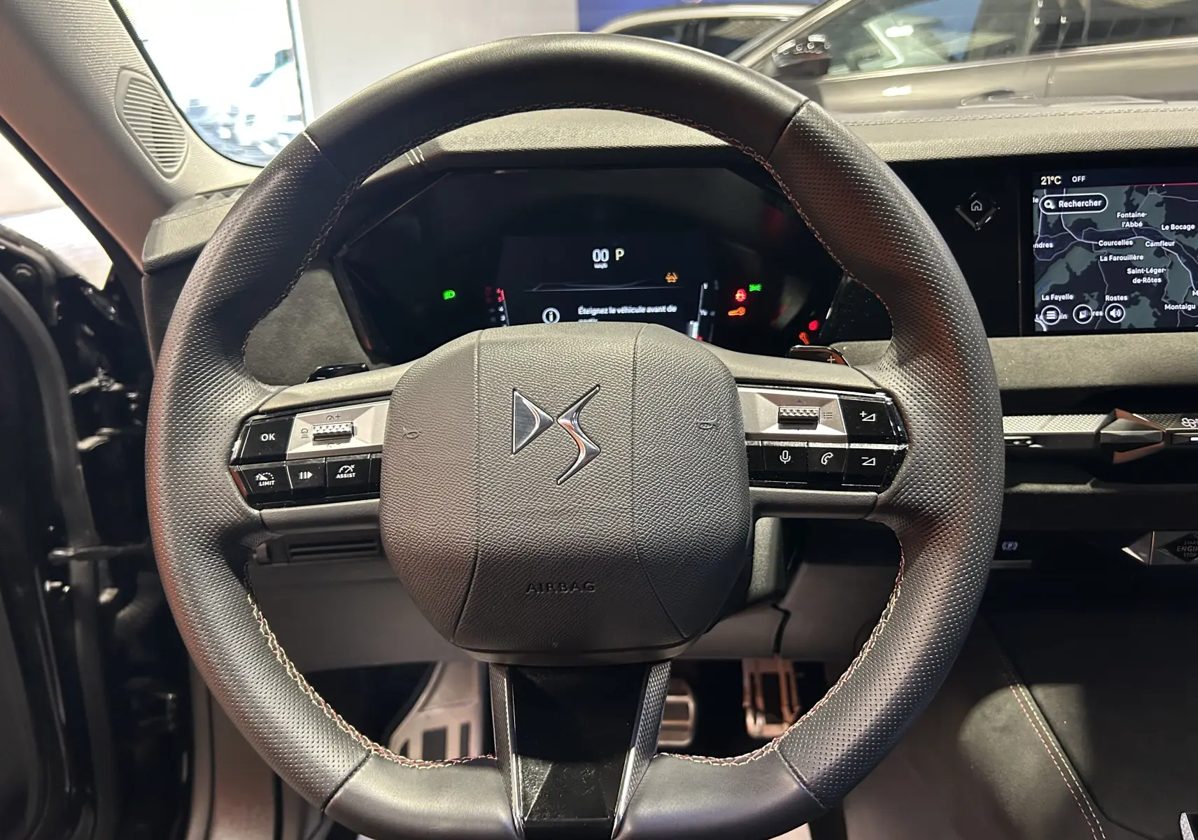 Volant en cuir perforé avec logo DS au centre, tableau de bord numérique et écran GPS visible sur DS4 noir Perla Nera 2024.