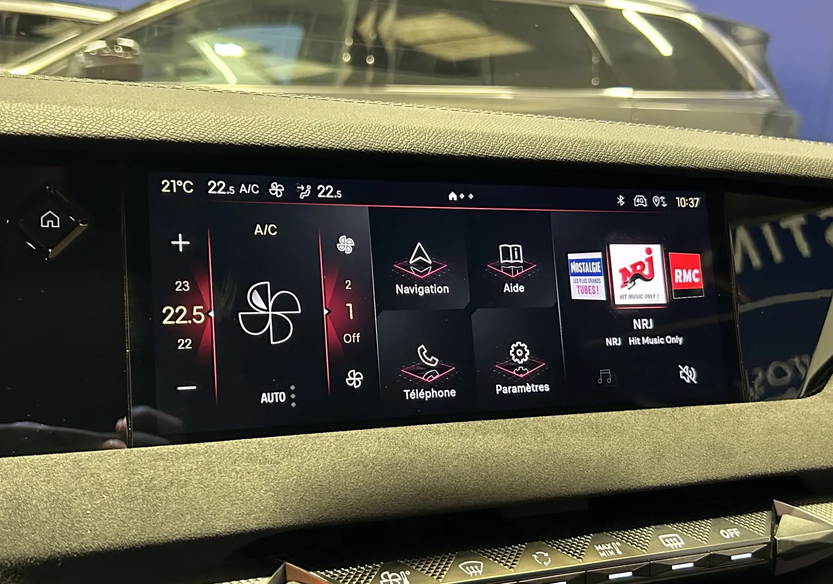 Écran tactile central du DS4 2024 affichant la climatisation, navigation et radio NRJ dans un intérieur noir.