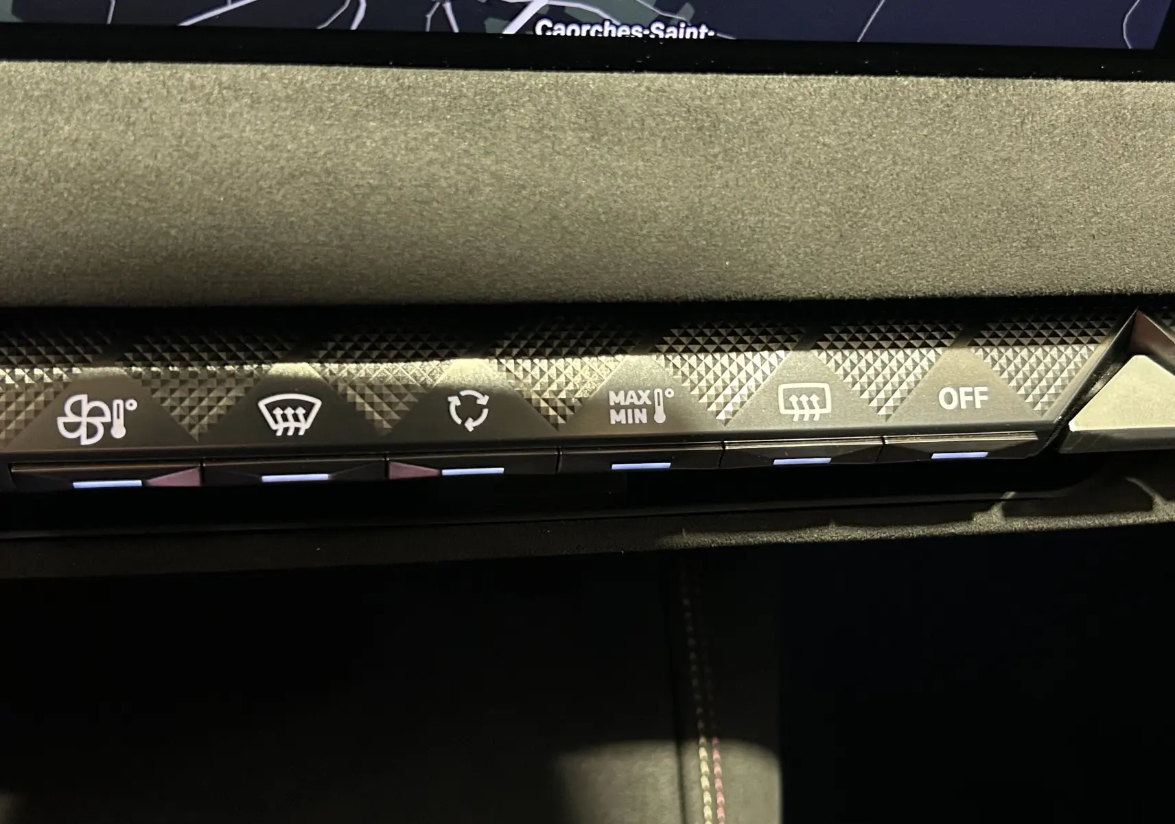 Gros plan sur la console centrale du DS4 2024 noir Perla Nera, montrant les commandes tactiles du climatiseur avec motifs géométriques.