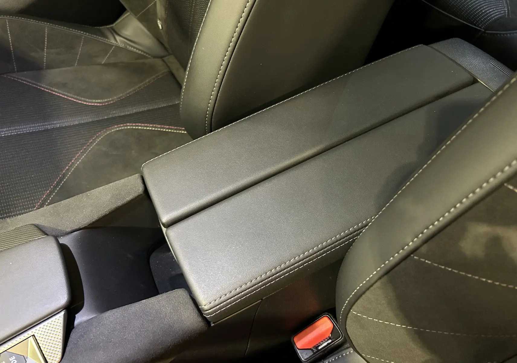 Gros plan sur l'accoudoir central en cuir noir avec surpiqûres blanches dans l'habitacle du DS4 2024.