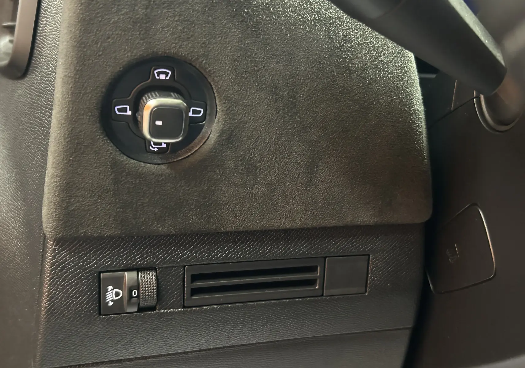 Détail du panneau de commande noir côté gauche du tableau de bord du DS4 2024 avec réglage des rétroviseurs et commande d'éclairage.