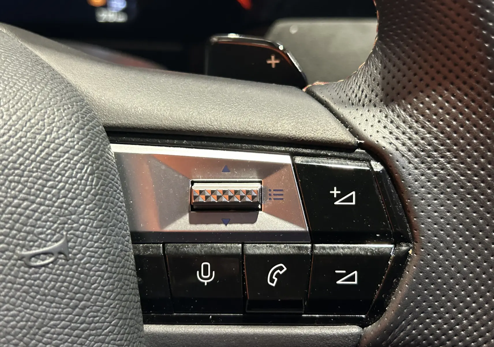 Gros plan sur les commandes vocales et volume au volant en cuir perforé du DS4 noir Perla Nera 2024.