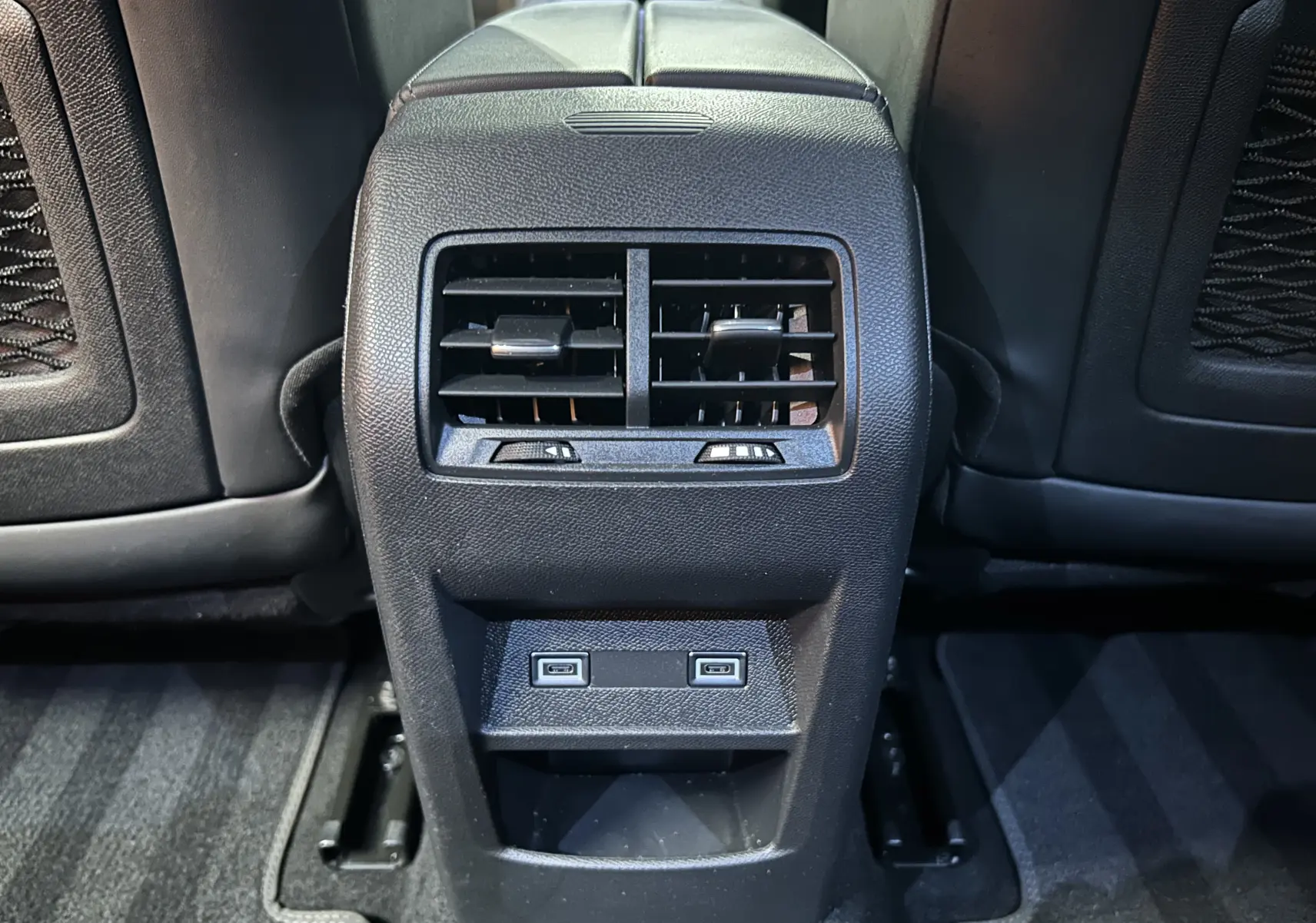 Vue rapprochée de la console arrière du DS4 2024 noir Perla Nera avec bouches d’aération et deux ports USB.